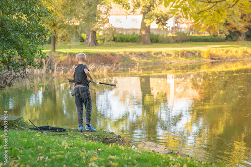 Wallpaper Mural Young fisherman at lake catches fish during summer time Torontodigital.ca