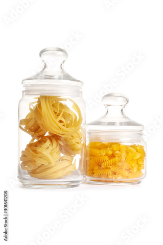 Raw pasta in a glass jar isolated on a white background.
