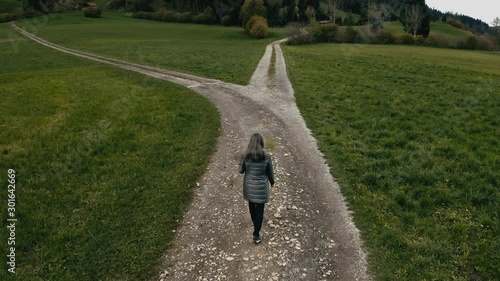 Woman at the crossroads. Symbol of choice.  Aerial shot from the drone.4K