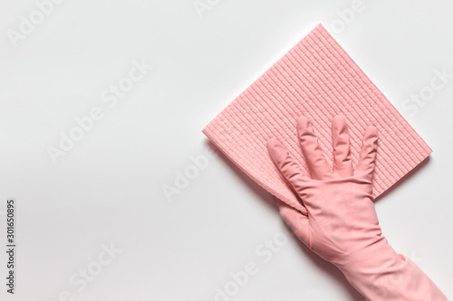Isolated hand in pink rubber glove with pink washing cloth on white backgound.