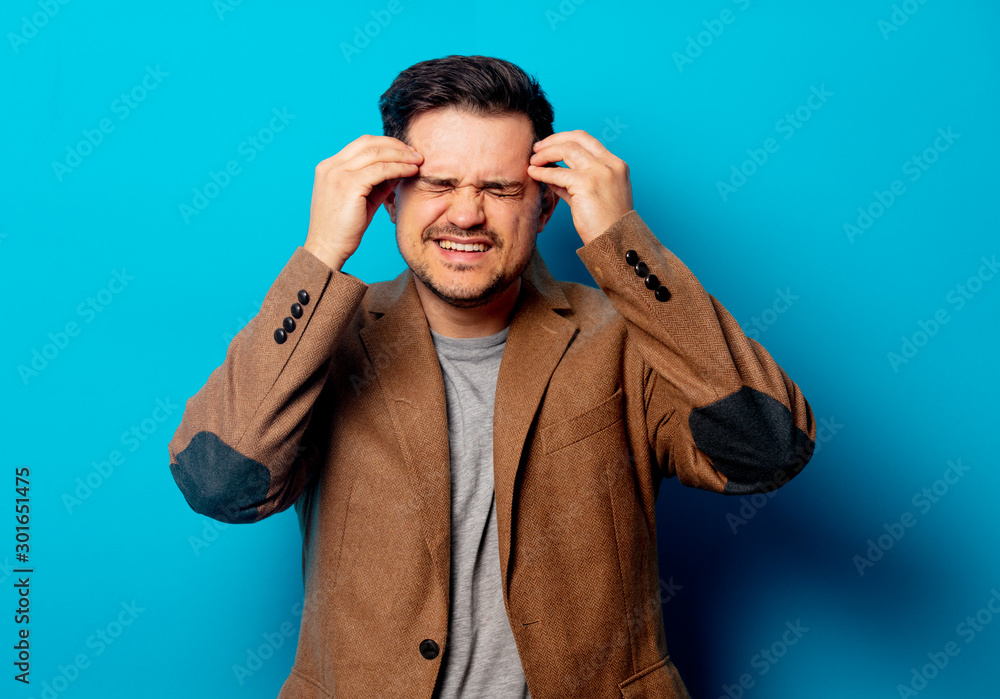 man with headache on blue background man with headache on blue background