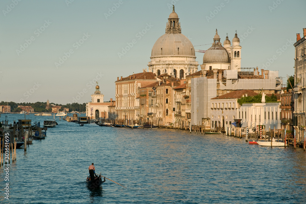 Grand Canal in Venice, Italy with single Gondola and domed church in background