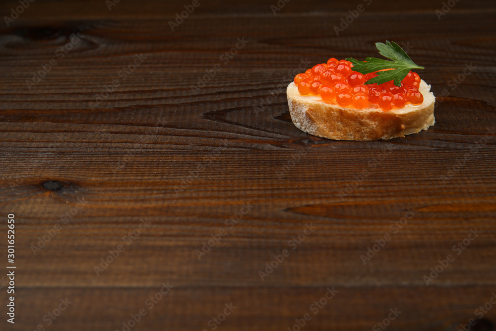 sandwich with red caviar on dark wooden surface with space for text sandwich with red caviar on dark wooden surface with space for text