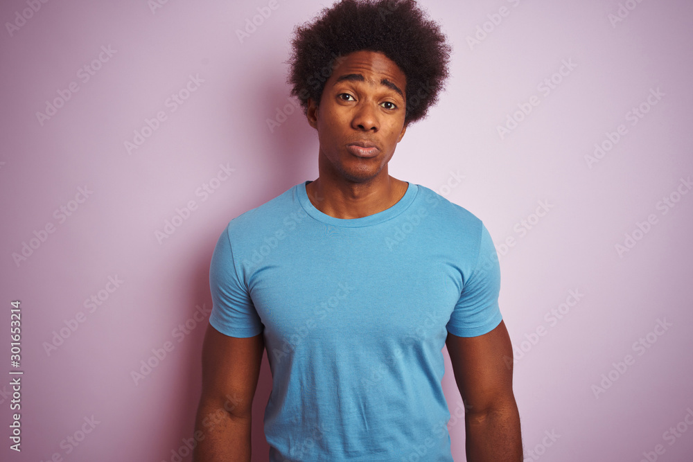 African american man with afro hair wearing blue t-shirt standing over isolated pink background depressed and worry for distress, crying angry and afraid. Sad expression. African american man with afro hair wearing blue t-shirt standing over isolated pink background depressed and worry for distress, crying angry and afraid. Sad expression.