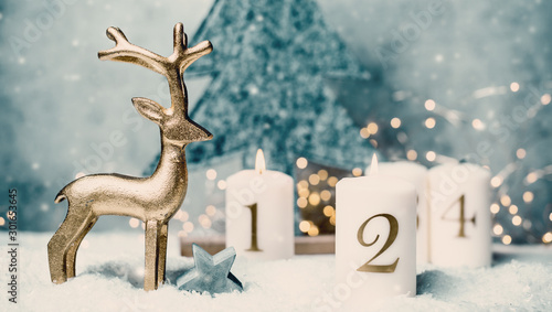 Advent candles 1  2 3 4 in front of concrete background and reindeer in the snow with colorful lights and gray trees