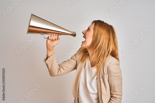 Fotografija Young beautiful readhead businesswoman screaming using vintage megaphone
