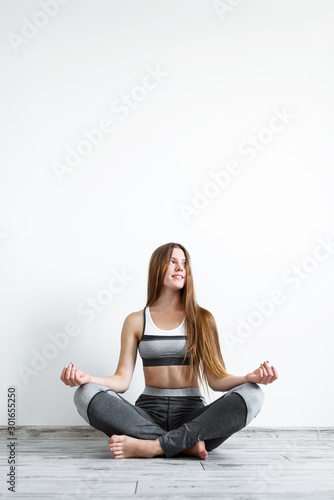 Beautiful girl practices yoga and meditation in the lotus position at home Free Download Beautiful girl practices yoga and meditation in the lotus position at home - GFXLoad