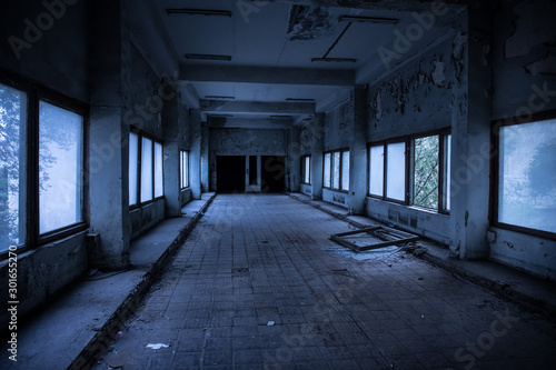 Dark, spooky tunnel, corridor with large windows at the end in abandoned building © zef art