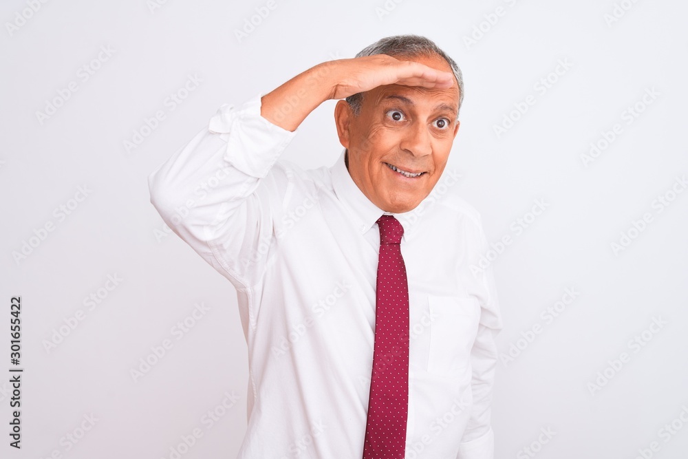 Senior grey-haired businessman wearing elegant tie over isolated white background very happy and smiling looking far away with hand over head. Searching concept. Senior grey-haired businessman wearing elegant tie over isolated white background very happy and smiling looking far away with hand over head. Searching concept.