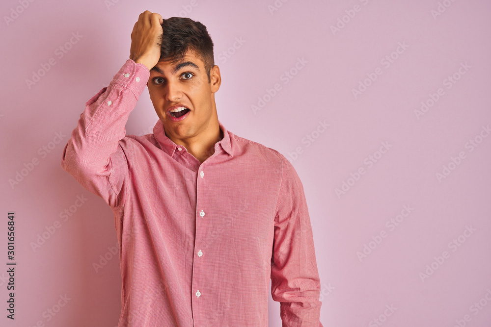 Young indian man wearing elegant shirt standing over isolated pink background surprised with hand on head for mistake, remember error. Forgot, bad memory concept. Young indian man wearing elegant shirt standing over isolated pink background surprised with hand on head for mistake, remember error. Forgot, bad memory concept.
