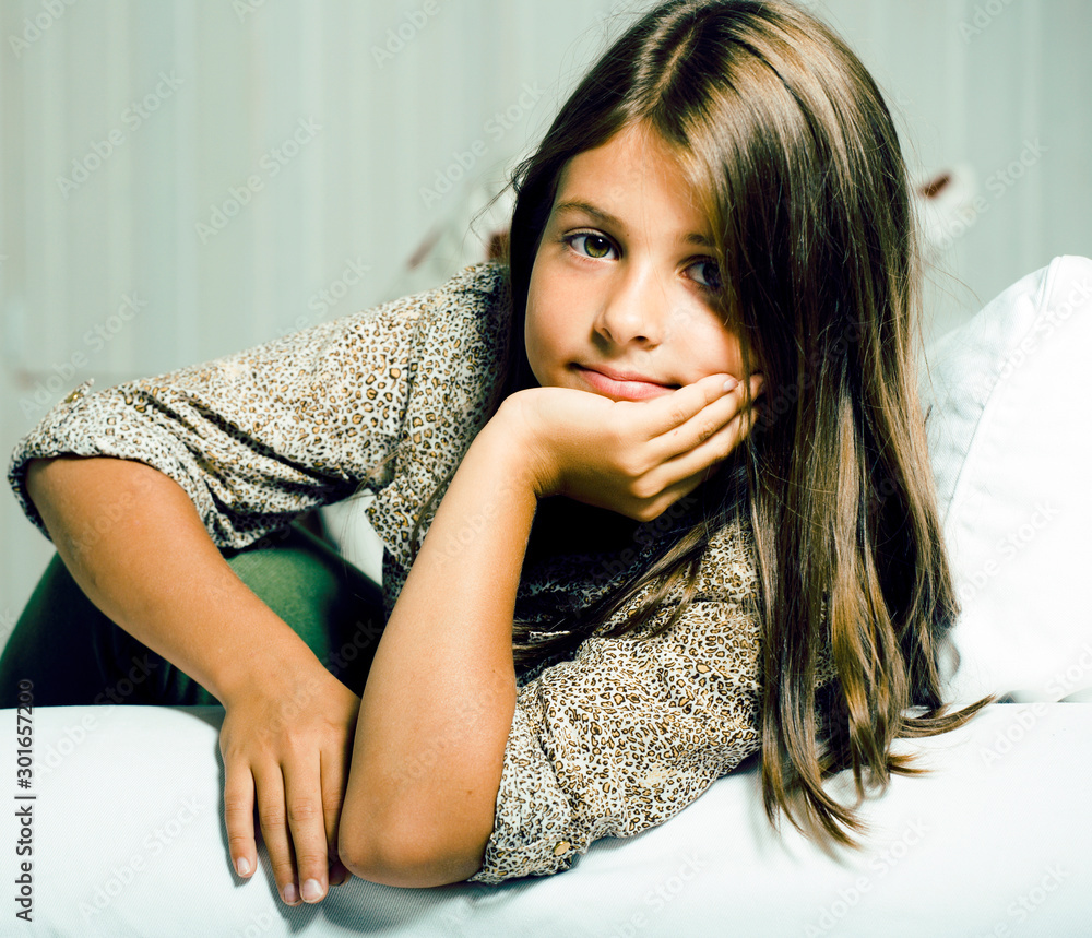 Naklejka premium little cute brunette girl at home interior happy smiling closeup, lifestyle real modern people concept