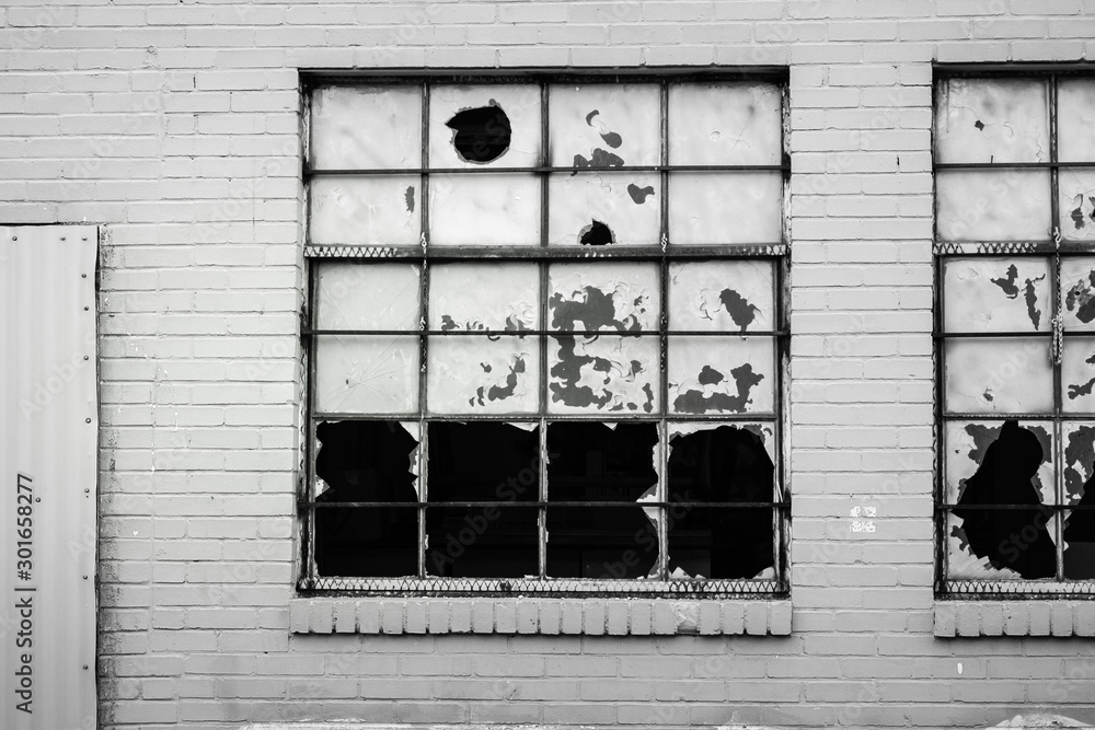 Light Pole in front of a building wall with broken windows in the city.