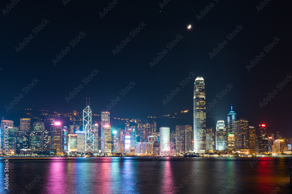 Victoria Harbour - Hong Kong skyline at night under the moonlight.