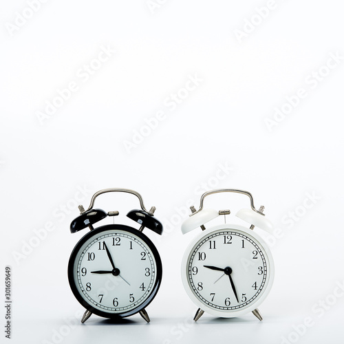 Black vintage alarm clock and White clock on white