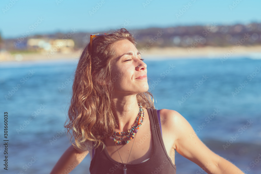 woman standing in the sun near the beach woman standing in the sun near the beach
