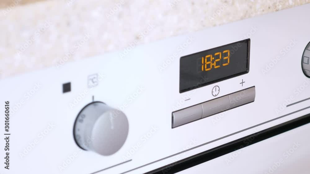 Woman setuping and adjusting oven. Prepare to cook food Woman setuping and adjusting oven. Prepare to cook food