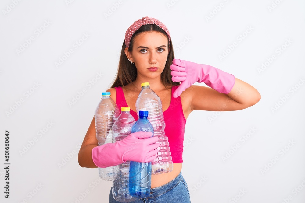 Beautiful girl wearing cleaner gloves recycling plastic bottles over isolated white background with angry face, negative sign showing dislike with thumbs down, rejection concept Beautiful girl wearing cleaner gloves recycling plastic bottles over isolated white background with angry face, negative sign showing dislike with thumbs down, rejection concept