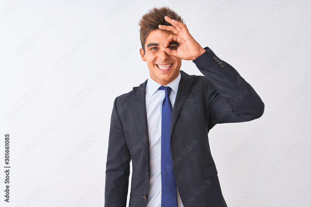 Young handsome businessman wearing suit standing over isolated white background doing ok gesture with hand smiling, eye looking through fingers with happy face. Young handsome businessman wearing suit standing over isolated white background doing ok gesture with hand smiling, eye looking through fingers with happy face.