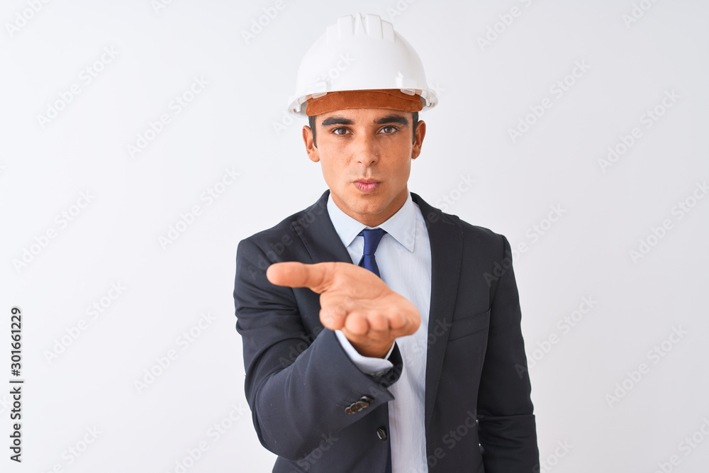 Young handsome architect man wearing suit and helmet over isolated white background looking at the camera blowing a kiss with hand on air being lovely and sexy. Love expression. Young handsome architect man wearing suit and helmet over isolated white background looking at the camera blowing a kiss with hand on air being lovely and sexy. Love expression.