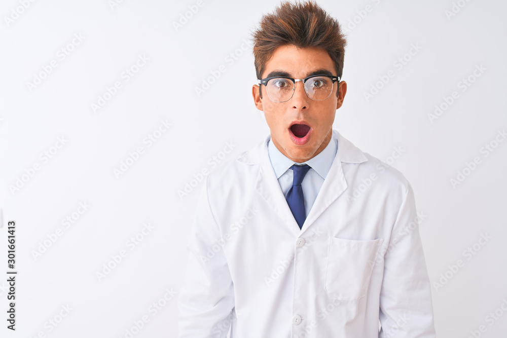 Young handsome sciencist man wearing glasses and coat over isolated white background afraid and shocked with surprise and amazed expression, fear and excited face. Young handsome sciencist man wearing glasses and coat over isolated white background afraid and shocked with surprise and amazed expression, fear and excited face.
