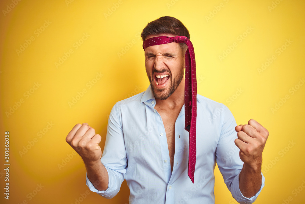 Hangover business man drunk and crazy for hangover wearing tie on head very happy and excited doing winner gesture with arms raised, smiling and screaming for success. Celebration concept. Hangover business man drunk and crazy for hangover wearing tie on head very happy and excited doing winner gesture with arms raised, smiling and screaming for success. Celebration concept.