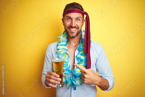 Hangover business man drunk and crazy for hangover wearing tie on head drinking beer very happy pointing with hand and finger photo