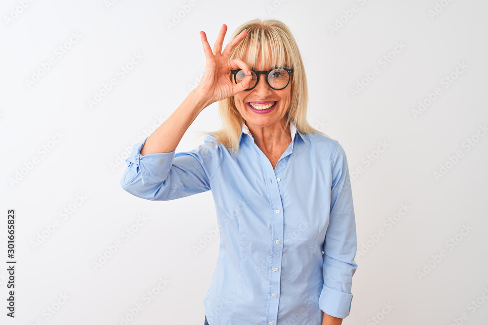 Obraz premium Middle age businesswoman wearing elegant shirt and glasses over isolated white background doing ok gesture with hand smiling, eye looking through fingers with happy face.