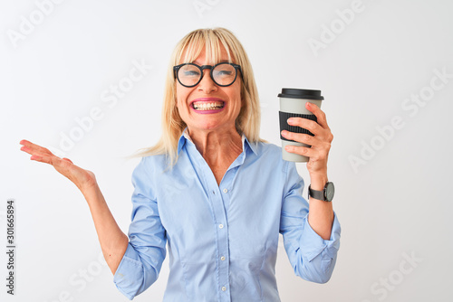 Middle age businesswoman wearing glasses drinking coffee over isolated white background very happy and excited, winner expression celebrating victory screaming with big smile and raised hands