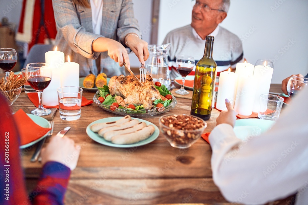 Beautiful group of people meeting smiling happy and confident. Carving roasted turkey celebrating Thanksgiving Day at home