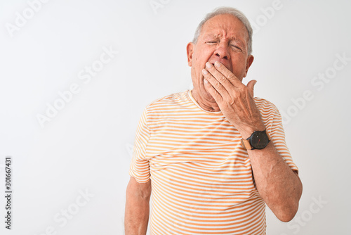 Photos Senior grey-haired man wearing striped t-shirt standing over isolated white background bored yawning tired covering mouth with hand