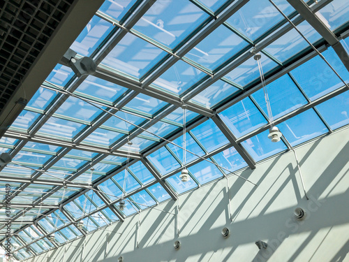 transparent glass ceiling of the modern building under bright blue sky