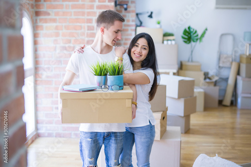 Young beautiful couple moving cardboard boxes at new home © Krakenimages.com