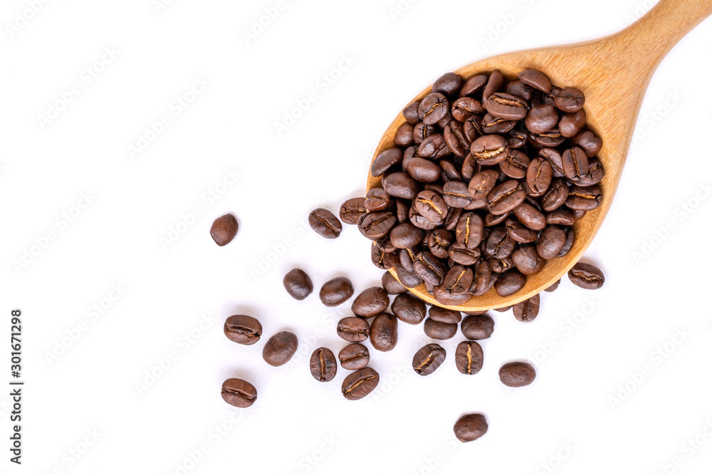 Obraz premium Closeup coffee beans in wooden spoon isolated on white background. Top view. Space for text.