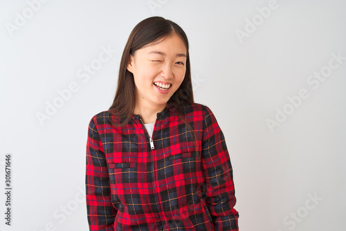 Young chinese woman wearing casual jacket standing over isolated white background winking looking at the camera with sexy expression, cheerful and happy face.