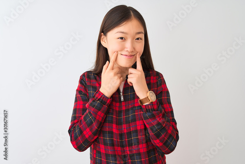 Young chinese woman wearing casual jacket standing over isolated white background Smiling with open mouth, fingers pointing and forcing cheerful smile © Krakenimages.com