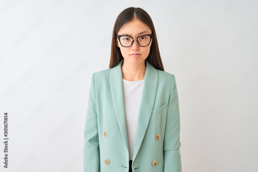 Chinese businesswoman wearing elegant jacket and glasses over isolated white background skeptic and nervous, frowning upset because of problem. Negative person. Chinese businesswoman wearing elegant jacket and glasses over isolated white background skeptic and nervous, frowning upset because of problem. Negative person.
