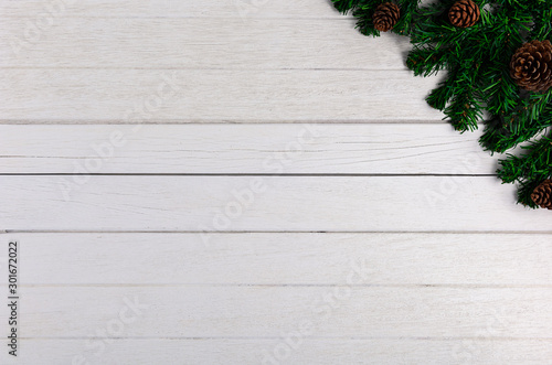 Fir branches and Pine cones on white wooden board
