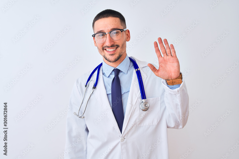 Young doctor man wearing stethoscope over isolated background Waiving saying hello happy and smiling, friendly welcome gesture Young doctor man wearing stethoscope over isolated background Waiving saying hello happy and smiling, friendly welcome gesture