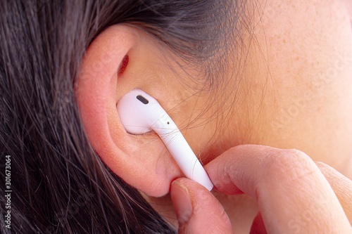 Female about to wear earphones or headphones on an horizontal view