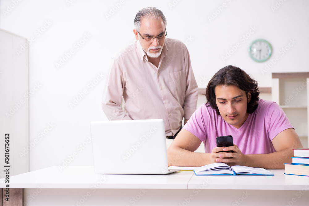 Old father helping his son in exam preparation Old father helping his son in exam preparation