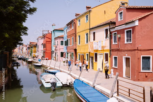 Panoramic view of coloured homes and water canal with boats in Burano