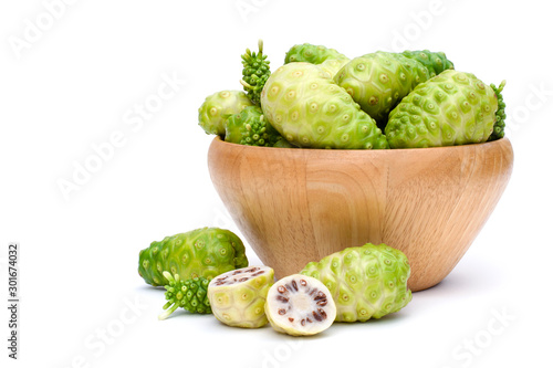 Closeup fresh Noni fruits (Common name Morinda citrifolia,indian mulberry, cheese fruit )in wooden bowl and cut in half sliced isolated on white background.Nature medicine plant and superfood concept 