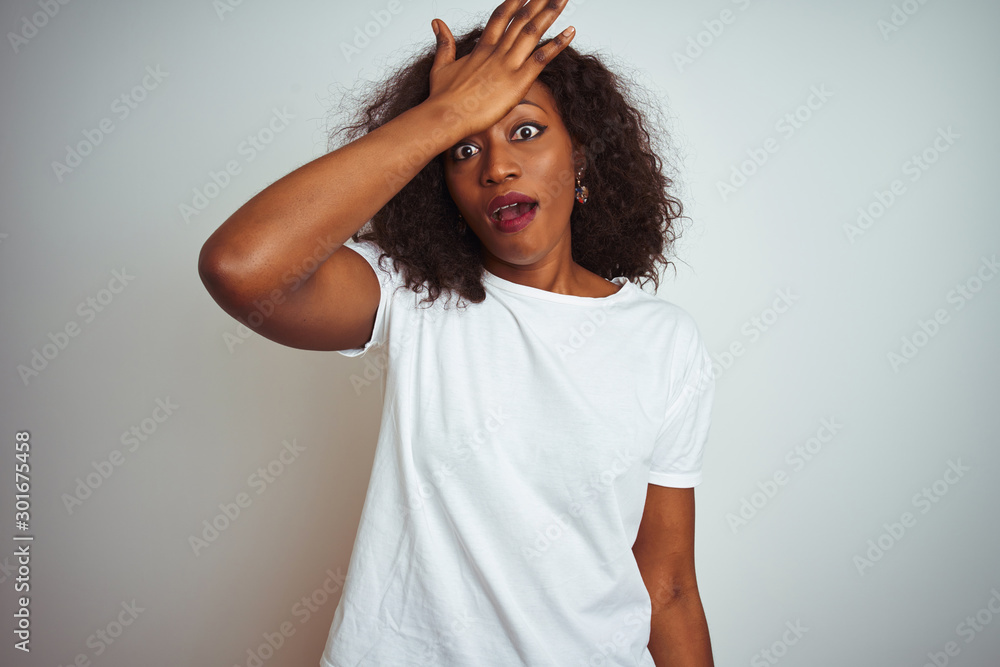 Young african american woman wearing t-shirt standing over isolated white background surprised with hand on head for mistake, remember error. Forgot, bad memory concept. Young african american woman wearing t-shirt standing over isolated white background surprised with hand on head for mistake, remember error. Forgot, bad memory concept.