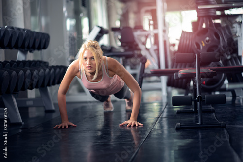 Strong woman doing push ups in the gym