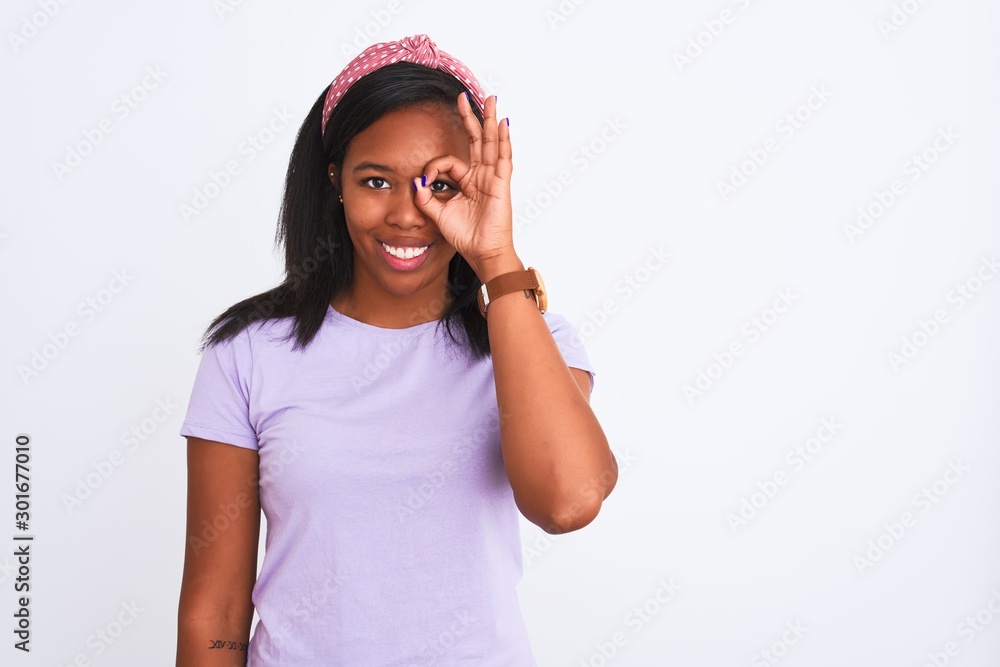 Beautiful young african american woman wearing a diadem over isolated background doing ok gesture with hand smiling, eye looking through fingers with happy face. Beautiful young african american woman wearing a diadem over isolated background doing ok gesture with hand smiling, eye looking through fingers with happy face.
