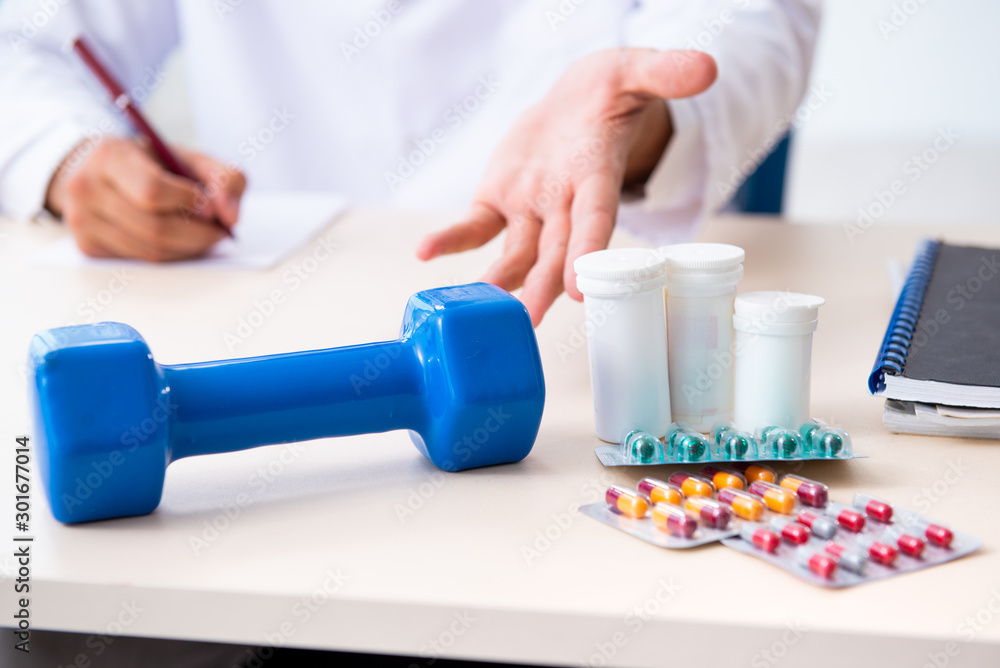 Young male doctor in sport and dieting concept Young male doctor in sport and dieting concept