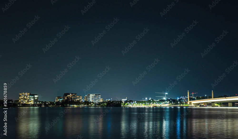 View of Canberra city at night looking over Lake Burley Griffin showing Commonwealth Bridge at right 