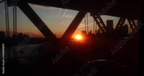 Stunning slow motion shot of train ride during sunset across the Williamsburg bridge, connecting Brooklyn and Manhattan in New York City. Brooklyn bridge in the background photo