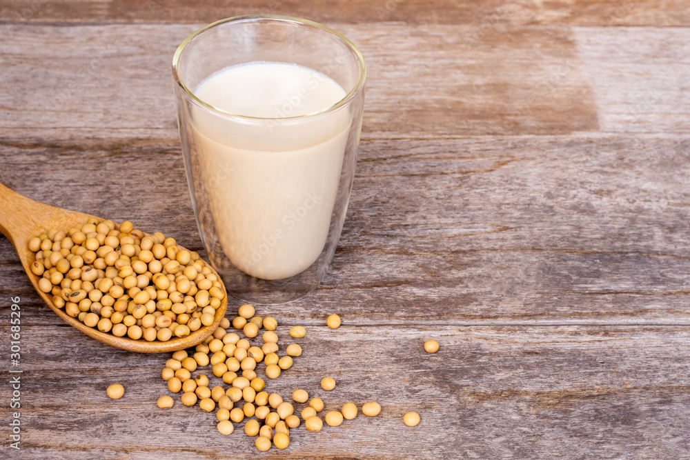 glass of fresh soymilk and soy beans on wooden table glass of fresh soymilk and soy beans on wooden table