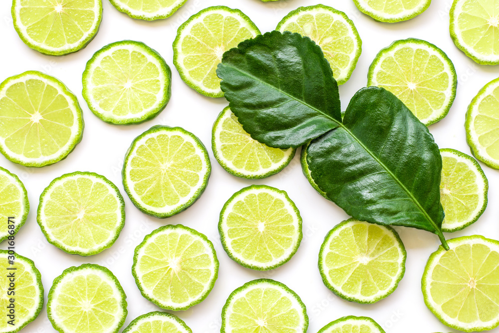 Fresh slices of bergamot fruits or kaffir lime and green leaf isolated on white background. Top view. Flat lay.